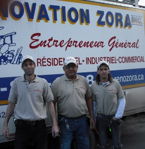 Salim Velji (centre) and two members of his renovation crew stand by the company white truck
