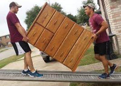Two movers carrying a dresser